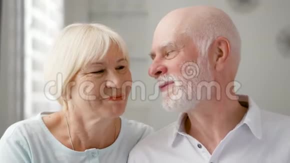 家中幸福的老夫妇的肖像老人表达情感亲吻妻子视频的预览图