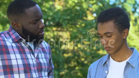 非裔美国人的父亲试图安慰不幸的儿子家庭支持信任视频的预览图