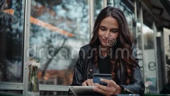 年轻女子拿着信用卡用笔记本电脑现代咖啡馆的网上购物理念视频的预览图