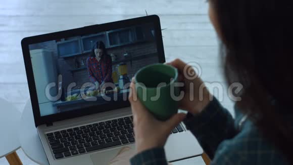 放松的女人在家里用笔记本电脑看视频视频的预览图