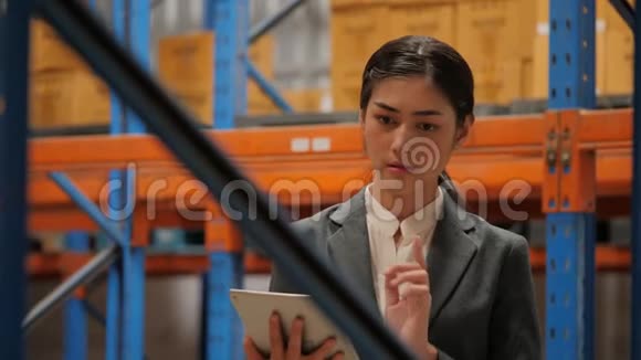 年轻女商人使用数码平板电脑检查工业仓库的存货视频的预览图