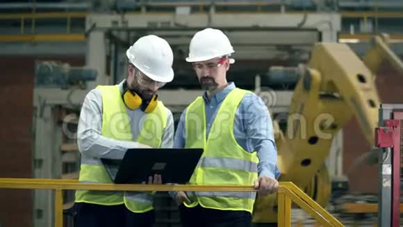 一家现代化工厂的男工程师现代工业工厂工人使用笔记本电脑视频的预览图