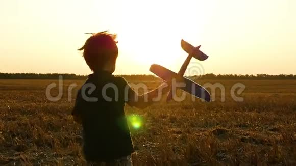 男孩在收割后穿过麦田孩子手里拿着一架玩具飞机想象着飞行视频的预览图