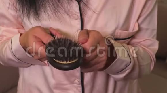女人从手中的梳子上取出头发脱发概念视频的预览图