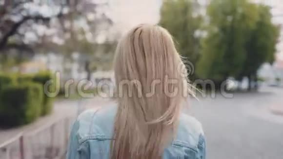 欧洲年轻的金发女郎正沿着公园移动然后她转过身来抛出樱桃的花瓣视频的预览图