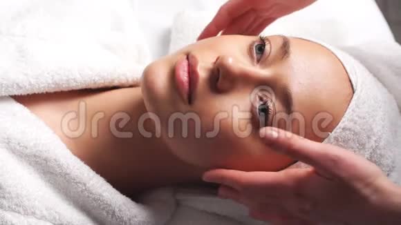 美丽的年轻女性放松女性接受面部身体按摩美容水疗视频的预览图