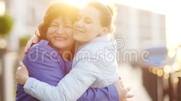 快乐的母亲和她的女儿女人轻轻拥抱欣喜地看着镜头家庭传统母亲视频的预览图