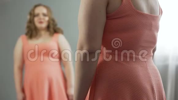 弯着腰的女士哭着责怪自己吃得太多变胖了视频的预览图