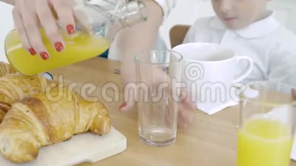雌性手的特写将橙汁倒入玻璃杯中早餐视频的预览图