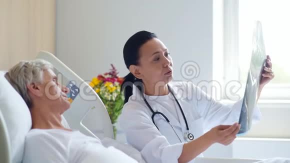 微笑的女医生和她的老年病人讨论x光扫描视频的预览图