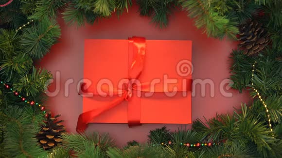 红色丝带解开和礼品盒与木制圣诞玩具打开装饰视频的预览图