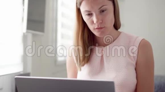 年轻女子在她的笔记本电脑屏幕上收到非常坏的消息对失败感到沮丧和沮丧视频的预览图