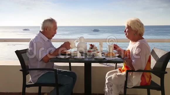 高级夫妇在酒店室外享用早餐视频的预览图