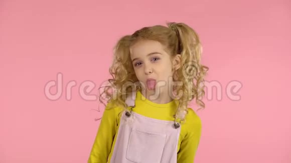 可爱的淘气女孩露出舌头做鬼脸视频的预览图