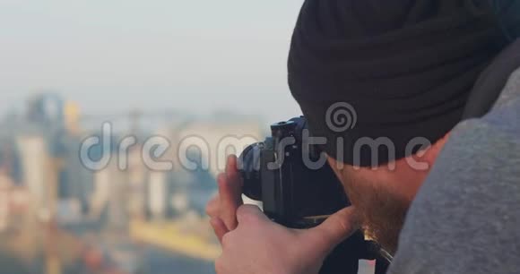 专业摄影师或录像师用三脚架从山上移走海港拍摄照片的摄影师视频的预览图