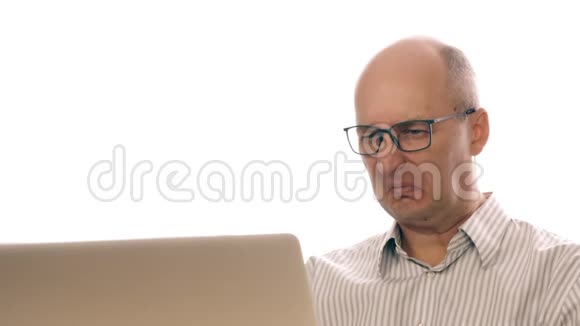 在笔记本电脑上工作的戴眼镜的商人看到了令人作呕的形象在办公室工作的时候男人表达了厌恶视频的预览图