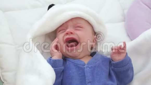 新生儿哭婴儿新出生的孩子又累又饿躺在蓝色针织毛毯下视频的预览图