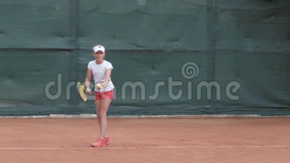 职业运动网球运动员青少年女孩集中注意力然后用球拍击球视频的预览图