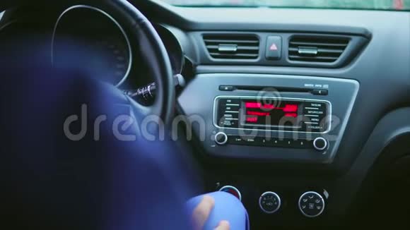在车的内部司机切换收音机设置和听音乐视频的预览图