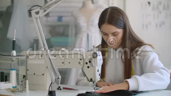 女时装设计师在车间用缝纫机工作的前景视频的预览图