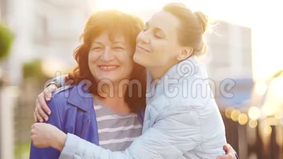 一个成熟的母亲和一个成年的女儿在街上相遇并拥抱家庭幸福世代延续母亲视频的预览图