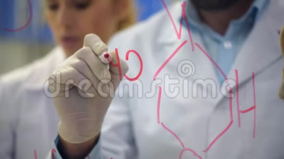 在玻璃上绘制化学配方的男性研究员视频的预览图