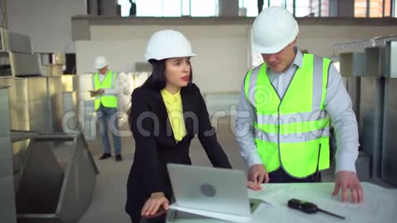 男性和女性仓库工人正在看一台笔记本电脑并讨论他们业务的物流问题4千克视频的预览图
