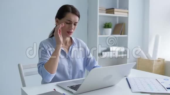 可怜的年轻女士在工作中头痛视频的预览图