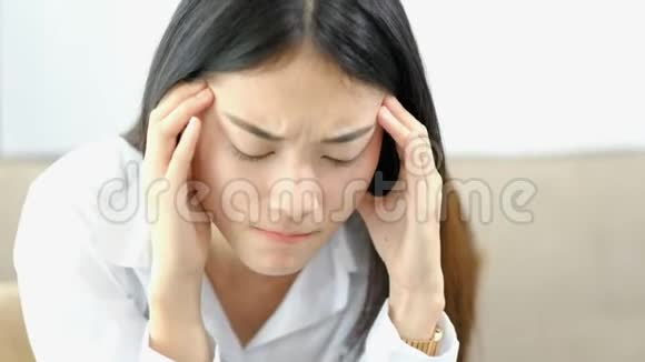 疲惫的商务女性在家庭办公室工作忙碌的亚洲女孩在工作中头痛健康问题焦虑视频的预览图