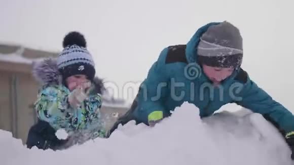 孩子们在雪山上玩耍扔雪和晴朗的霜天新鲜空气中的乐趣和游戏视频的预览图
