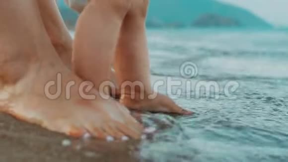 妈妈和宝宝的脚站在海滩上家庭暑假假期视频的预览图