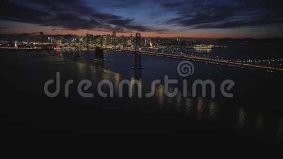 华丽的空中拍摄大钢金门大桥旧金山市中心的天际线照亮了夜晚的灯光城市景观视频的预览图