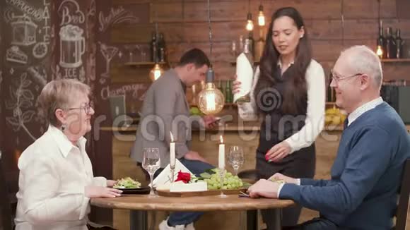 女服务员在约会时给一对老夫妇倒酒视频的预览图