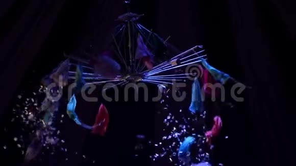 从马戏团的穹顶下在探照灯的照耀下纸屑和小降落伞落下视频的预览图