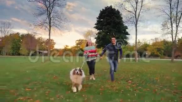 亚洲男人和高加索女人和他的狗在公园里跑步一起快乐一起欢笑视频的预览图