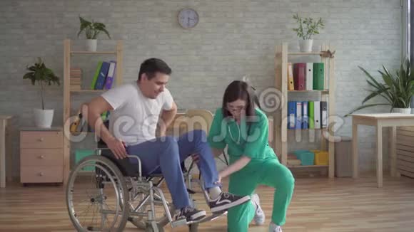 女护士帮助残疾人从轮椅上站起来视频的预览图