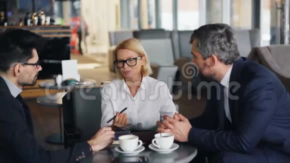 商务女性与男性合伙人谈判协议在咖啡馆开会视频的预览图