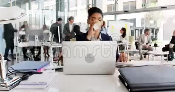 女商人在办公桌前喝咖啡的时间视频的预览图