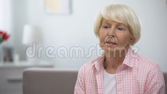 令人不安的老年妇女独自坐在养老院被亲戚遗弃视频的预览图