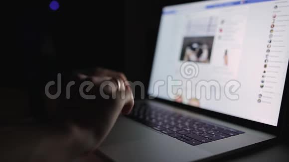 男人正在工作打字在深夜在家里的办公室使用笔记本电脑社交媒体facebook浏览视频的预览图