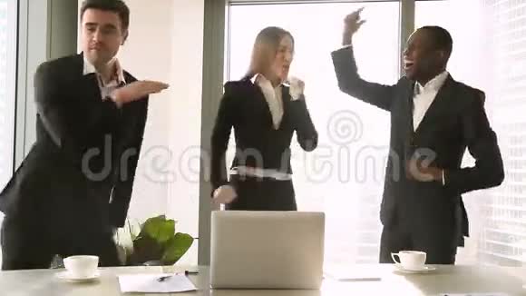 三个兴奋的商人在工作场所跳舞庆祝胜利视频的预览图