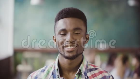 年轻成功的非洲商人在繁忙的办公室的肖像英俊的男性看着相机开始微笑视频的预览图
