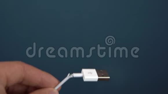 撕裂USB电缆特写一个人手里拿着一根撕裂的铁丝电线磨损视频的预览图