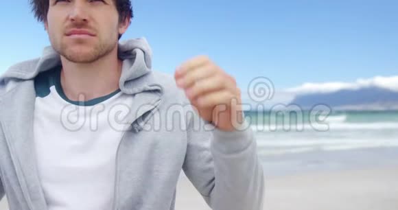 在海滩穿帽衫的人视频的预览图