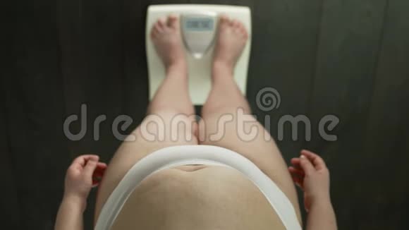 女人站在天平上屏幕上有肥胖的字眼节食失败很生气视频的预览图