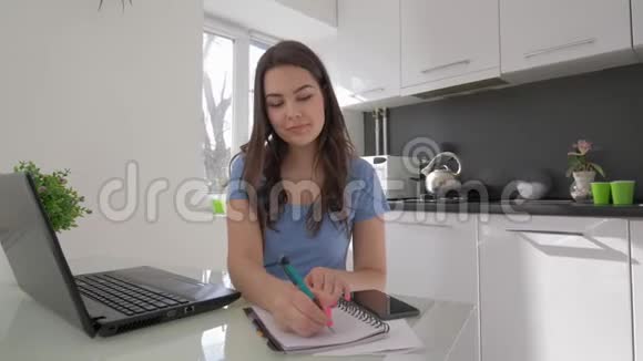 自由工作快乐的年轻女子在厨房做饭时用手提电脑工作视频的预览图