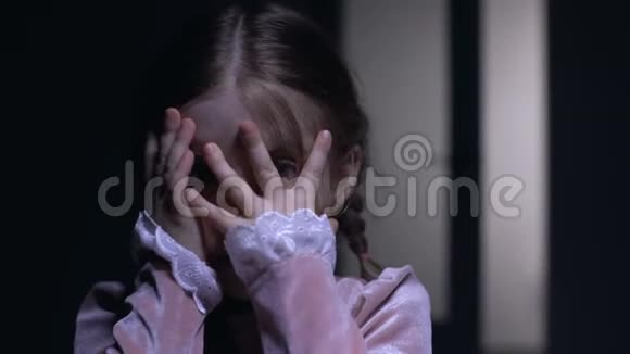 惊恐的小女孩用手掌闭上脸害怕鬼魂恐惧症的概念视频的预览图