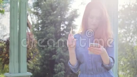 年轻的红发妇女使用手机网上购物和网上银行支付费用视频的预览图