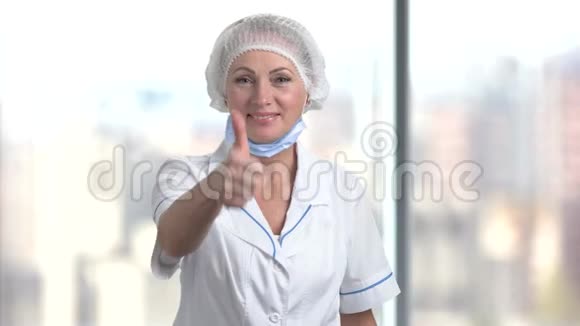 微笑成熟的女医生伸出大拇指视频的预览图