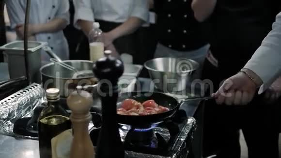 厨师大师班厨师在炒锅里用火做饭专业厨师在商业厨房里用火焰式烹饪视频的预览图